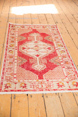 Distressed cherry red Oushak runner showcasing geometric ivory patterns and fringed edge.