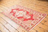 Oushak runner corner showcasing distressed cherry red pile, ivory lattice spandrel, and fringe.