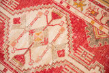 Distressed vintage Oushak rug showing geometric pattern with serrated ivory outlines.