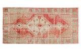 Vintage distressed Oushak runner displays faded red geometric medallion, ivory field, pale aqua border.