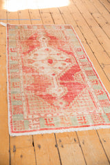Textured distressed pile and white fringe of a vintage Oushak runner with pale aqua border.