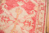 Distressed Oushak rug showing raspberry red, ivory serrated leaf pattern and visible foundation.