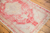 Hand-knotted distressed vintage Oushak rug with faded raspberry red and ivory floral motifs.