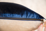 Brass zipper fastening plush cobalt velvet to natural linen.