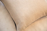 Natural linen texture on throw pillow back with dark piped edge.