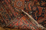 Hand-knotted vintage Hamadan runner: red and blue Herati pattern, exposed back weave, tattered edge.