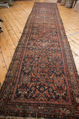 Vintage Hamadan runner showing intricate Herati motif on dark navy with red Serbend border.