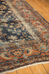 Vintage Mahal carpet with navy floral field, terra cotta palmette border, and wear.
