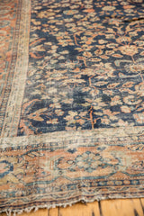 Vintage Mahal rug detail: navy, terra cotta floral blossoms, meandering vine border, hard wear, tattered fringe.