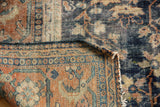 Mahal carpet detail: hard wear exposing navy blue foundation and frayed terra cotta border.