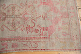 Vintage distressed Oushak rug corner highlighting intact selvage, even wear, and soft blush tones.
