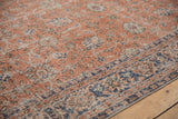 Distressed soft red Oushak texture with faded floral vinery and denim blue border.