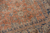 Distressed Oushak rug with soft red, ivory, denim blue floral vinery and visible foundation.