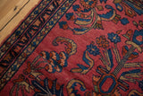 Raspberry red field of Vintage Lilihan rug with blue floral palmettes and vine border.