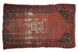 Antique Kurdish Hamadan rug with worn madder red boteh field, ivory medallion, navy blue borders.