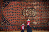 Antique Kurdish Hamadan rug showing asymmetric ivory medallion, madder red boteh field, and localized wear.