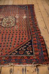 Kurdish Hamadan rug corner, navy spandrel with floral cross-sections, inverted botehs, worn fringe.