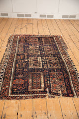 Antique Belouch fragment with geometric double column patterns, dark navy, madder red, and visible reduction.