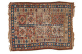 Antique Caucasian rug with geometric medallions, brick red, sky blue, and beige.