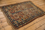 Worn antique Caucasian rug, geometric medallions, hook motifs, foundation, brick red, sky blue.