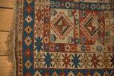 Early 20th century Caucasian rug: geometric panels, hook and latch motifs, visible foundation wear.