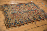 Antique Caucasian rug's paneled design, geometric medallions, hook motifs in brick red, sky blue, and wear.