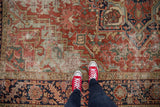 Worn pile of antique Heriz carpet, with geometric vinery in cherry red and navy.