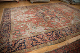 Antique Heriz carpet with geometric quatrefoil medallion, rectilinear vinery, and rich cherry red.