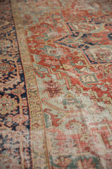 Antique Heriz carpet detail, showing cherry red, mallard green vinery, and visible foundation.