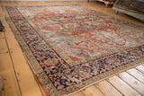 Antique Heriz rug corner featuring aged texture, navy geometric border, poly-chrome selvage.