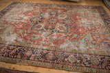 Antique Heriz carpet, worn field of cherry red, powder blue with navy border detail.