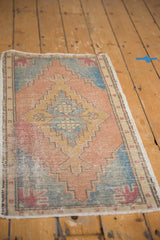 Detail of vintage distressed Oushak rug, showing stepped medallion, worn texture, soft terra cotta and blue.