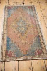Distressed Oushak rug's lower left corner, sky blue, terra cotta, and beige geometric design.