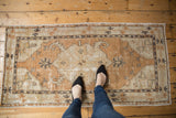 Distressed Oushak rug runner, dusty copper and ivory palette, showing soft pile and textural wear.