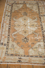 Distressed vintage Oushak rug corner, showing dusty copper field, antique ivory border, and geometric sickle motifs.