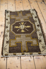 Distressed vintage Oushak mat with primitive geometric medallion, brown and ivory.
