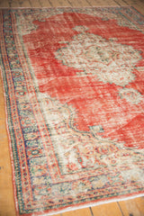 Close-up of distressed vintage Oushak carpet, wear across to knot heads, faded red, ivory.