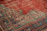 Distressed vintage Oushak carpet, showing cherry red field and intricate ivory and blue patterns.