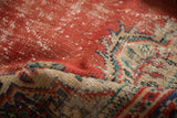 Distressed texture of vintage Oushak rug in worn cherry red, mint green, and antique ivory.