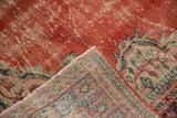 Distressed cherry red Oushak pile, revealing knot heads and intricate woven reverse pattern.
