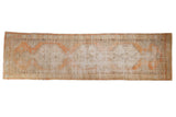 Vintage distressed Oushak runner with interconnected medallions in faded orange, sand, and ivory, 2'8