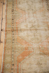 Distressed vintage Oushak runner's low pile with pale terra cotta, sand, and brown tones.