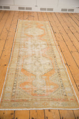 Long distressed vintage Oushak runner with pale orange, sand, and ivory colors.