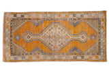 Distressed vintage Oushak runner with a diamond medallion, plant spandrels, saffron, and ivory.