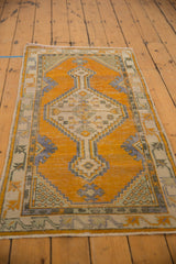 Distressed vintage Oushak rug runner with saffron yellow field, showing germinating plant spandrels and short fringe.