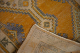 Vintage Oushak runner folded, revealing distressed saffron orange pile and hand-knotted back.