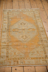 Evenly worn dusty tangerine orange and antique ivory geometric Oushak rug pattern.