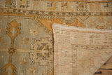 Corner of vintage distressed Oushak runner showing worn orange pile, woven foundation, and selvage.