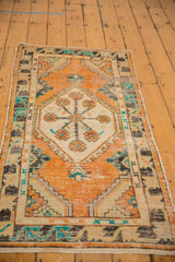 Distressed tangerine orange field, ivory floral medallion, and turquoise meandering vine border.