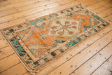 Distressed tangerine orange pile of vintage Oushak rug runner, showing foundation and fringe.
